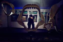 bride and groom in museum behind shark jaws